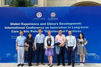 A group of people standing in front of a sign

Description automatically generated