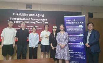 A group of people standing in front of a sign

Description automatically generated
